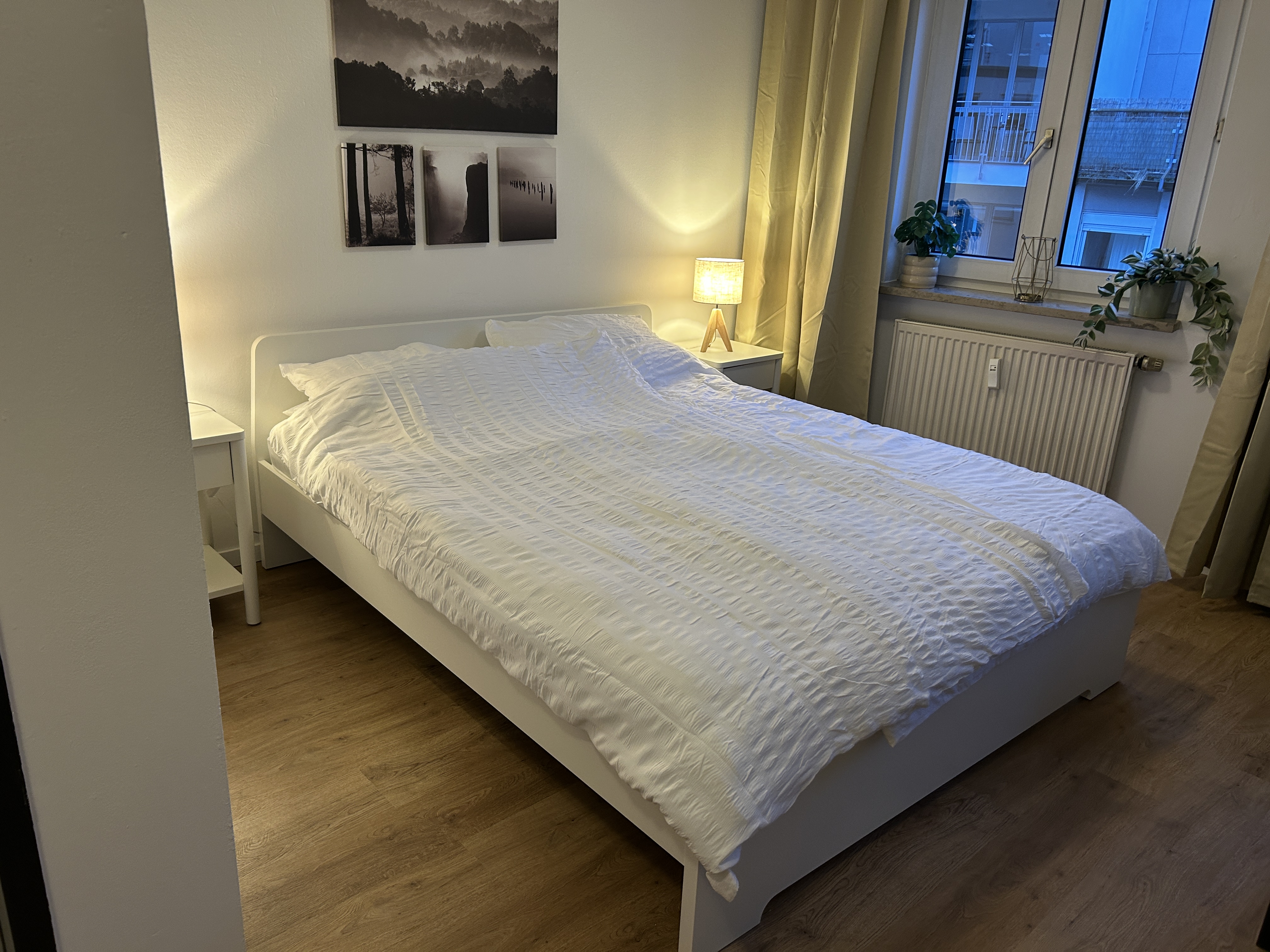 City Studio bedroom with white bedding and night lamps