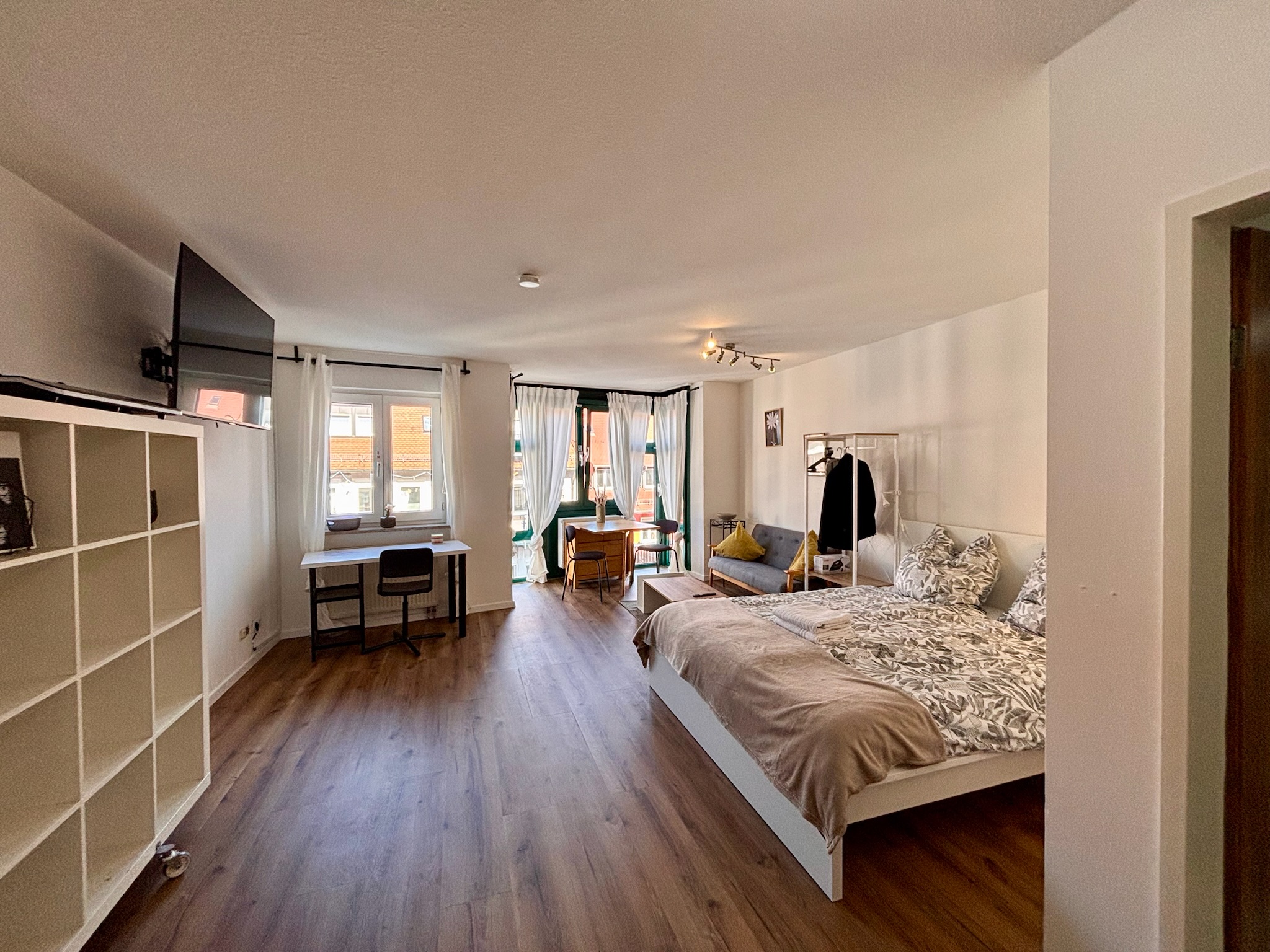 Grand Studio full interior with bed, sofa and windows